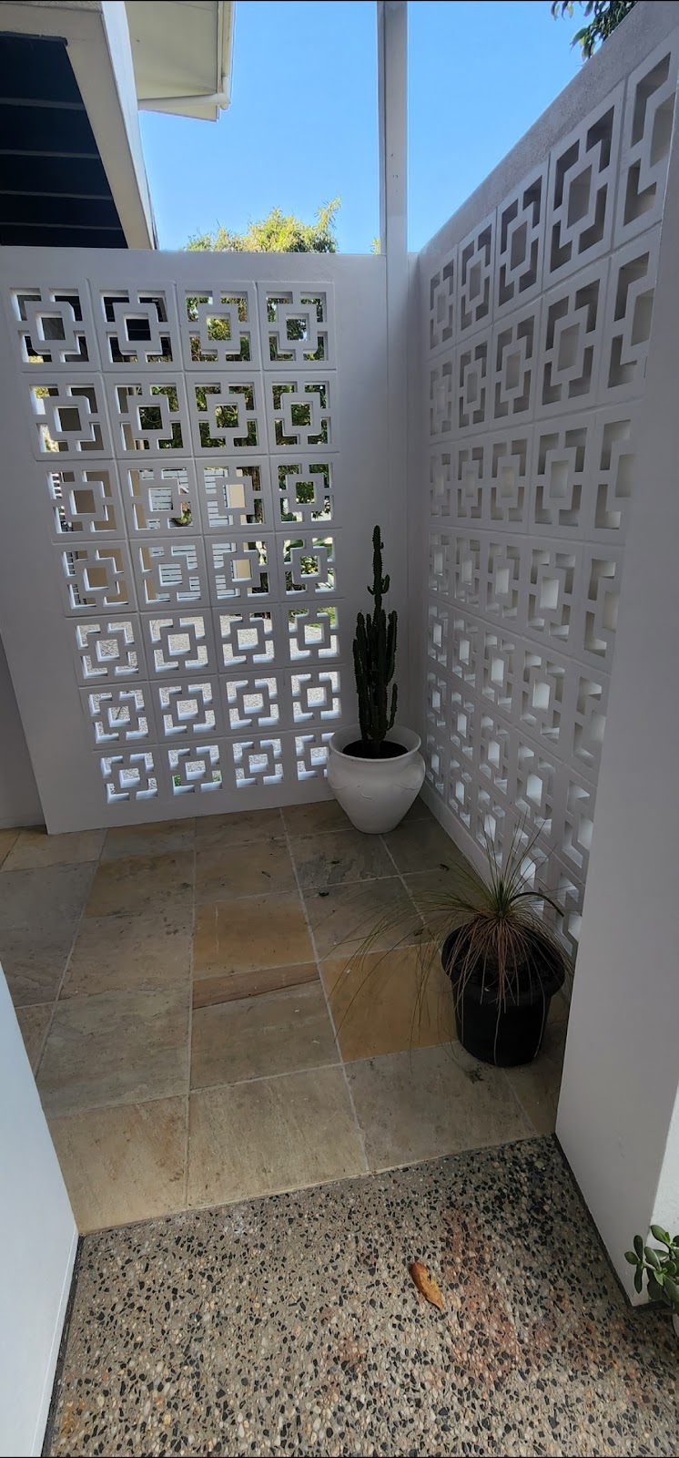 White decorative breeze-block screen walls around a small tiled courtyard
